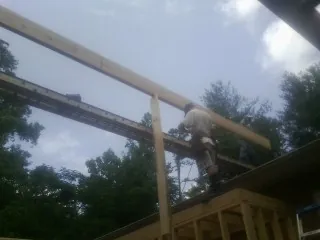 Carpenter setting a ridge beam over a new addition frame — Ice Dam Removal by Roofing Brothers in Asheboro