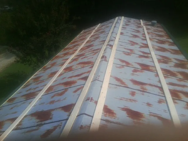 Rusted metal roof panels with new wood purlins before replacement — Storm Damage Roof Repair in Asheboro by Roofing Brothers
