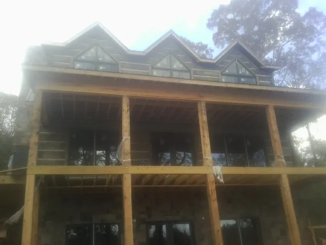 Dormers and porch framing on a large log home under construction — Roof Coating work by our crew in Asheboro
