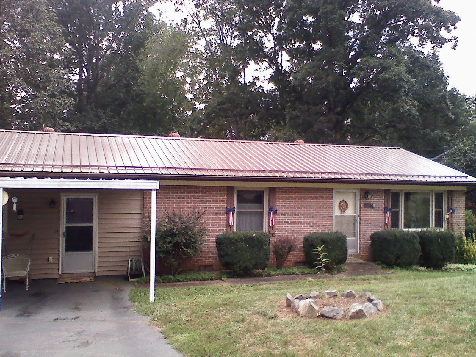 Bronze metal roof and carport on a brick ranch home — Roof Repair work by our crew in Asheboro