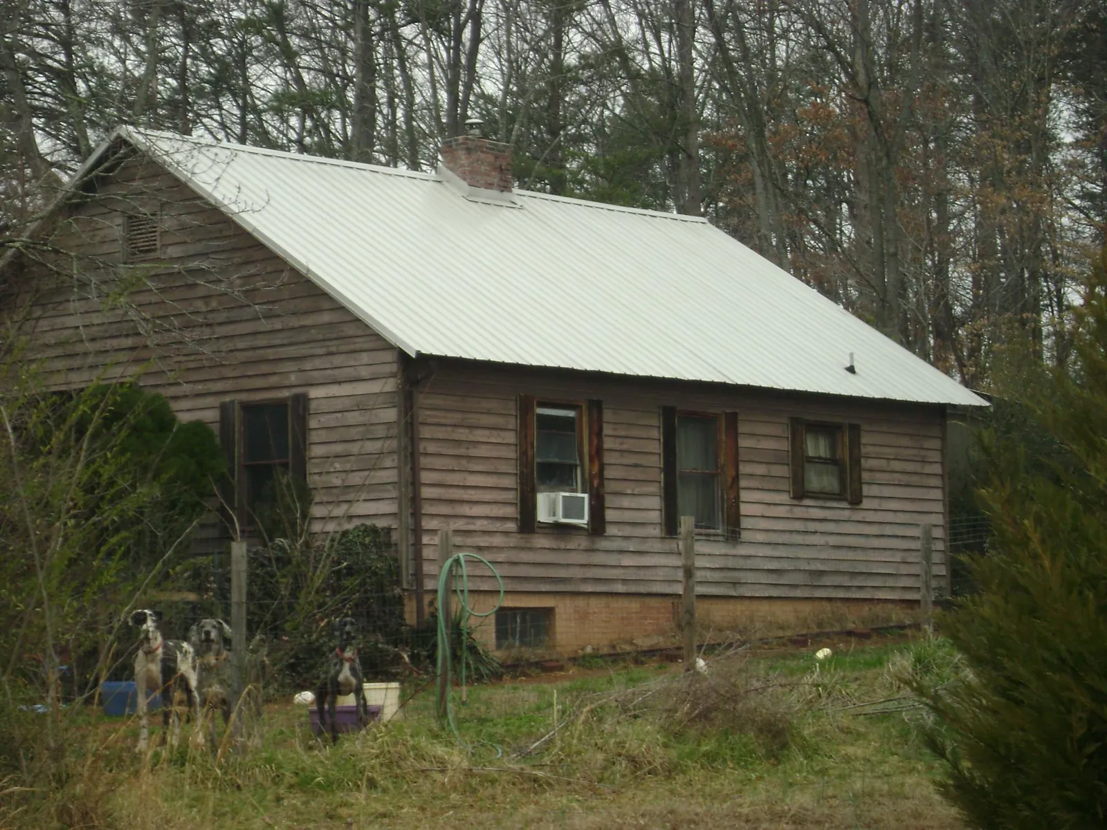 White metal roof on an old wood sided farmhouse, from a Asphalt Shingle Roof Repair job in Asheboro